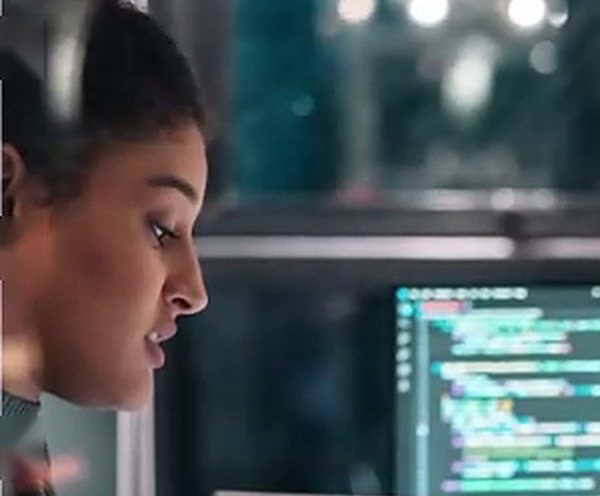 A colleague in conversation in front of screens of code
